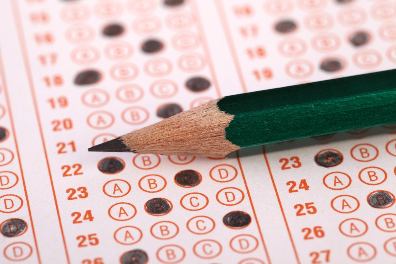 Close-up of filled in multiple choice exam and a green pencil