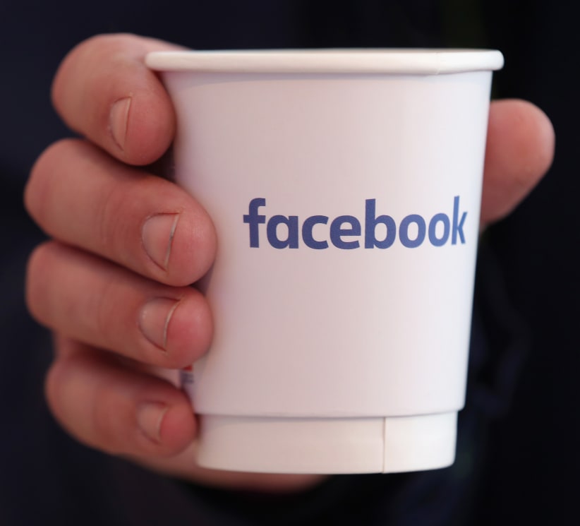BERLIN, GERMANY - FEBRUARY 24:  A visitor holds a paper coffee cup adorned with the Facebook logo at the Facebook Innovation Hub on February 24, 2016 in Berlin, Germany. The Facebook Innovation Hub is a temporary exhibition space where the company is showcasing some of its newest technologies and projects.  (Photo by Sean Gallup/Getty Images)