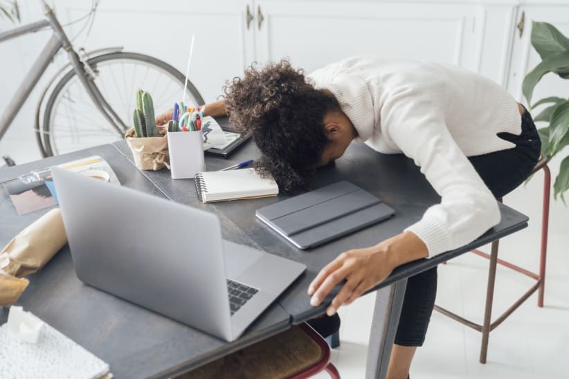 Overworked woman with her head resting on her desk