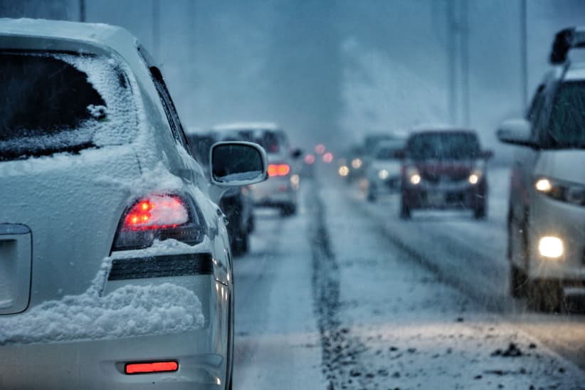 Cars driving on icy, snowy road