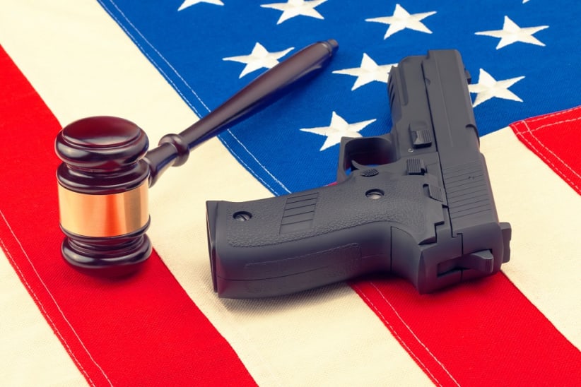 Judge gavel and gun over american flag - studio shot. Filtered image: cross processed vintage effect.