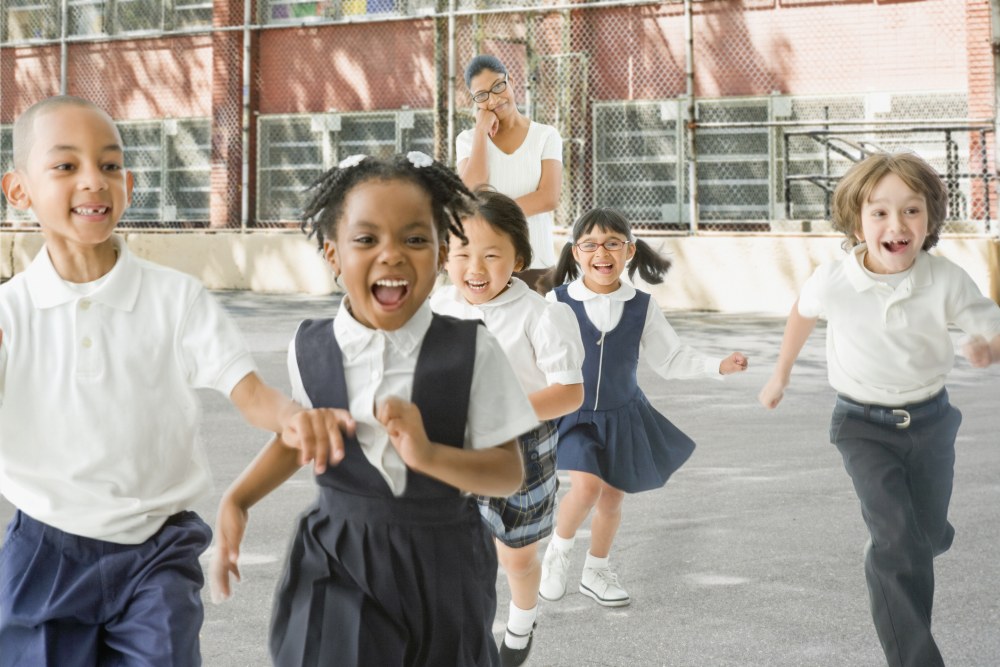 Grade school children running on a playground at recess